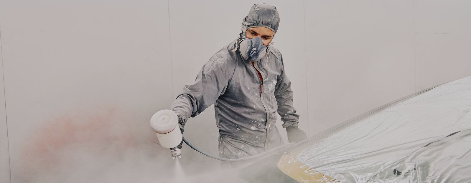 a man in uniform painting a car