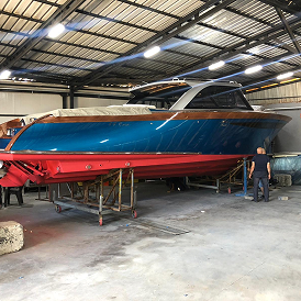 a man in uniform painting a boat